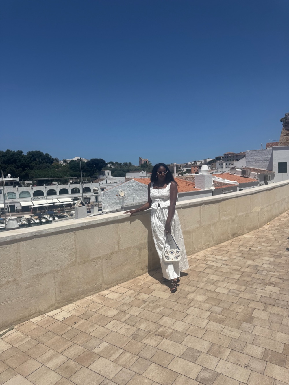 Rashana wearing white while overlooking a Mediterranean marina